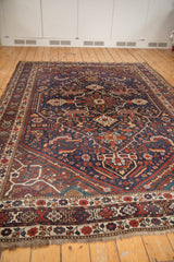Shiraz carpet border with red floral motifs, natural fringe, and faint foundation.