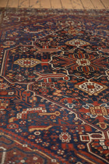 Vintage Shiraz carpet: angled detail of cobalt, red, ivory geometric serpent motifs.