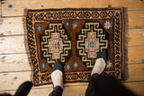 A vintage Oushak mat with double medallions shown from an overhead view for scale.