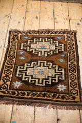 Vintage Oushak mat with primitive geometric medallions in brown, beige, and sky blue accents.