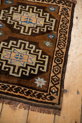 Geometric border and hook and latch motifs on a chocolate brown vintage Oushak rug.
