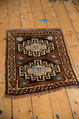 Vintage Oushak mat viewed from an angle, with geometric double medallions in brown and blue.