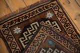 Folded corner of a vintage Oushak rug revealing the hand-knotted weave and geometric design.
