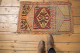 Distressed vintage Oushak rug with an asymmetric left spandrel, featuring tangerine floral petals.