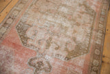 Distressed vintage Oushak runner pile, highlighting dusty blush and oxidized bronze medallion.