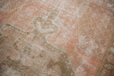 Vintage Oushak rug texture with even wear, dusty blush and oxidized bronze tones.