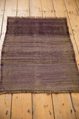 Overdyed aubergine violet Turkish kilim end, with horizontal striations and intact selvage.
