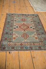 Distressed vintage Afghani rug corner, with germinating tree motif in ivory, seafoam, and chestnut.