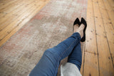 Distressed Oushak rug runner with time-softened blush, beige, and oxidized silver tones.