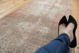 Close-up of distressed vintage Oushak runner with dusty blush and beige geometric pattern.