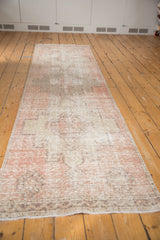Detail of worn foundation, secured fringe, and blush tones of the Oushak rug.