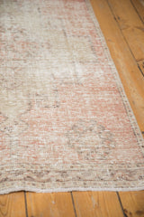 Distressed hand-knotted Oushak runner texture, dusty blush and beige, with visible knot heads.
