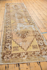 Long vintage distressed Oushak runner with faded saffron and brown patterns.