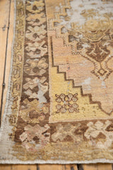 Distressed Oushak runner's secured side edge, worn floral border, and exposed foundation.