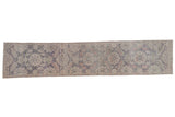 Distressed vintage Oushak runner with faded violet and denim blue single column floral design.
