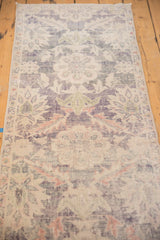 Textured close-up of the distressed Oushak runner, faded violet, denim blue, and ivory.