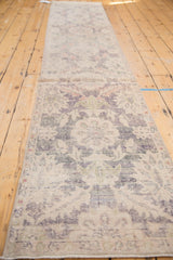 Distressed vintage Oushak runner showing faded violet, denim blue tones and even wear.