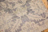 Evenly worn texture of a distressed Oushak rug with faded violet and blue hues.