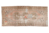 Distressed vintage Oushak runner with pale blush, coffee brown, and aqua blue tones, featuring patchwork fragments.