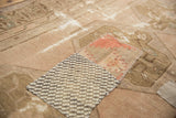 Playful patchwork fragments with checkered brown and distressed blush on vintage Oushak.