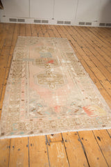 Playful zigzag patchwork fragment on distressed Oushak rug corner with fringe.
