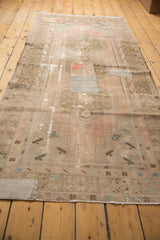 Overall distressed texture on vintage Oushak runner with faded blush and brown tones.