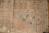 Distressed vintage Oushak patchwork rug detail in pale blush, brown, aqua, exposed foundation.
