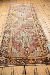 Distressed vintage Oushak runner, geometric medallion, patchwork kilim, visible foundation.