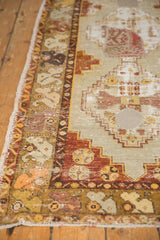 Distressed vintage Oushak rug with circular kilim patchwork, worn pile, and faded colors.