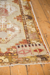 Decorative geometric kilim patchwork on distressed Oushak runner, faded reds, saffron, and pale blue.