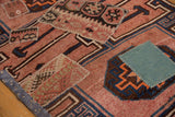 Hand-sewn kilim patchwork detail in blush, navy, and teal on a distressed Kars rug.