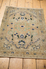 Distressed Hamadan rug texture with worn beige field, faded navy and mint floral motifs.