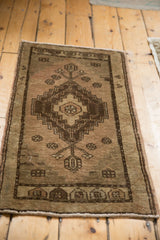 Distressed vintage Oushak rug, faded beige and chocolate, geometric diamond and plant motifs.