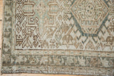 Distressed Karaja rug edge showing serrated geometric patterns and faint foundation.