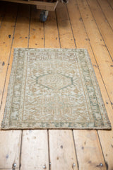 Distressed Karaja rug's bottom edge displaying reduced fringe and geometric pattern in sand and silver tones.