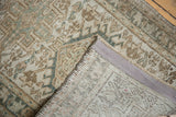 Distressed vintage Karaja rug's hand-knotted backing, secured edge, and geometric pattern.