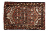 Vintage distressed Hamadan rug mat with geometric floral motif in dusty rust, ivory, and beige.