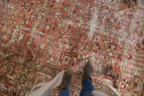 Distressed vintage Heriz carpet with geometric floral patterns, featuring raspberry and sage abrashes.