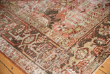 Distressed Heriz carpet, geometric florals in raspberry, charcoal, sage, worn to foundation.