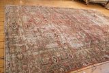 Distressed vintage Heriz carpet, worn geometric floral motifs in pale raspberry, sage, silver.