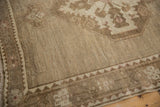 Distressed Oushak carpet corner with low-pile texture and tone-on-tone geometric border.