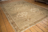 Distressed Oushak rug showcasing tone-on-tone medallions, abrashed field, and low pile texture.