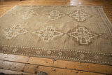 Distressed low pile vintage Oushak rug showing sand medallion and border.