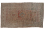 Distressed Oushak carpet with faded triple medallions, geometric blossoms, and muted rose, ivory, green.