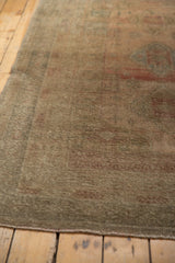 Low pile texture and muted blush, ocean green, and beige tones of a distressed vintage Oushak rug.