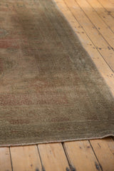 Low pile texture and muted tones on the secured fringe of the Oushak carpet.