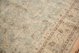 Textured detail of distressed Sparta carpet, showing muted ocean green, beige, and coffee brown lattice leaves.