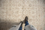 Distressed Turkish Sparta carpet, faded ivory, apricot floral vinery, mostly even wear.