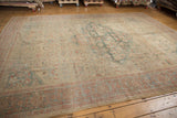 Distressed antique Sultanabad carpet corner with sky blue samovar border and faded Herati pattern.