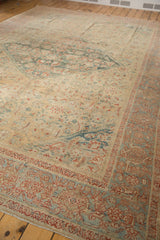 Antique Sultanabad rug corner with distressed low pile, quarter map spandrel, and muted samovar border.